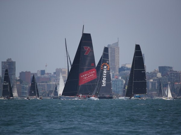 a large ship in a body of water with a city in the background