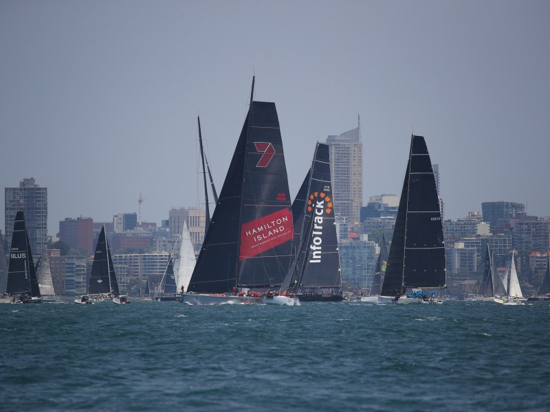 a large ship in a body of water with a city in the background