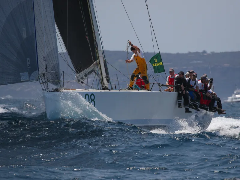 a group of people riding on the back of a boat in the water