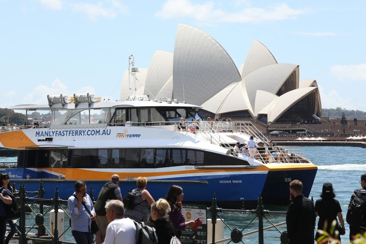 a group of people standing in front of a large ship in the water