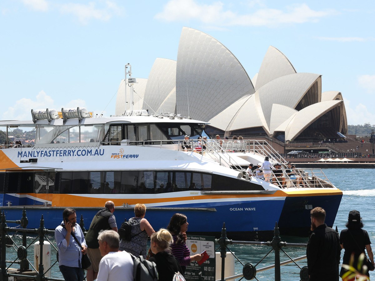 a group of people standing in front of a large ship in the water