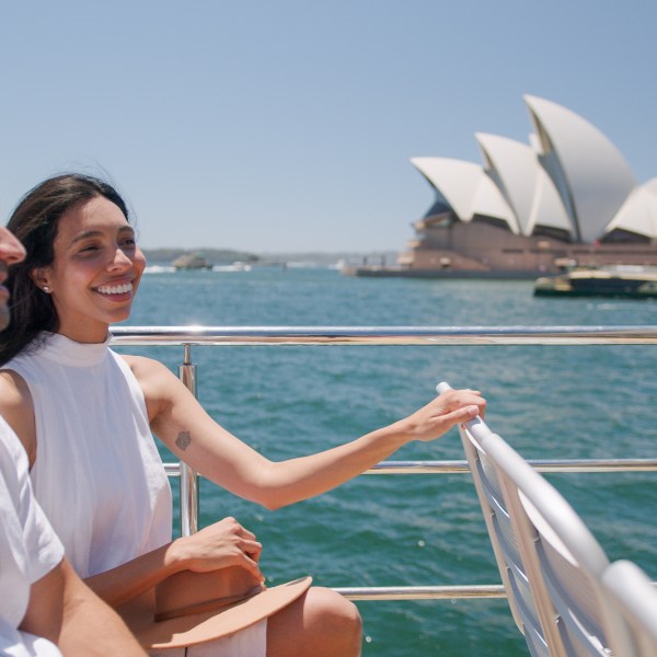 a person standing in front of a boat next to a body of water
