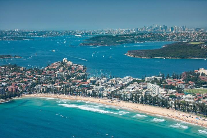 a crowded beach next to a body of water
