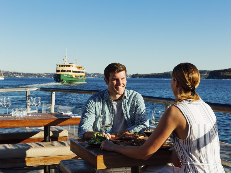 Alex Loudon sitting on a bench next to a body of water