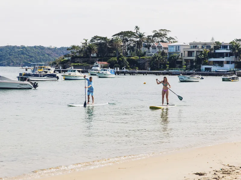 a group of people on a beach near a body of water