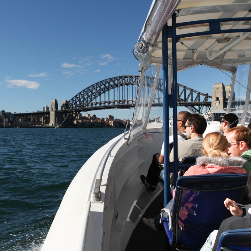 a man standing in front of a boat next to a body of water