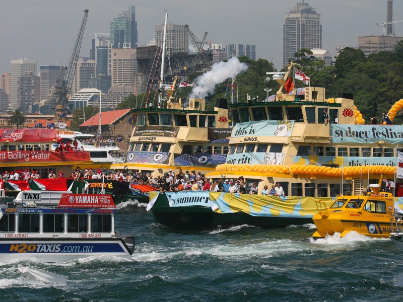 a large ship in the water with a city in the background