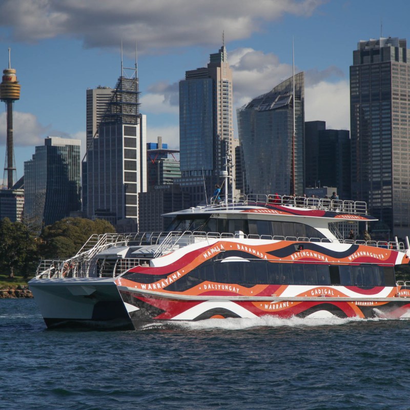 a large ship in a body of water with a city in the background