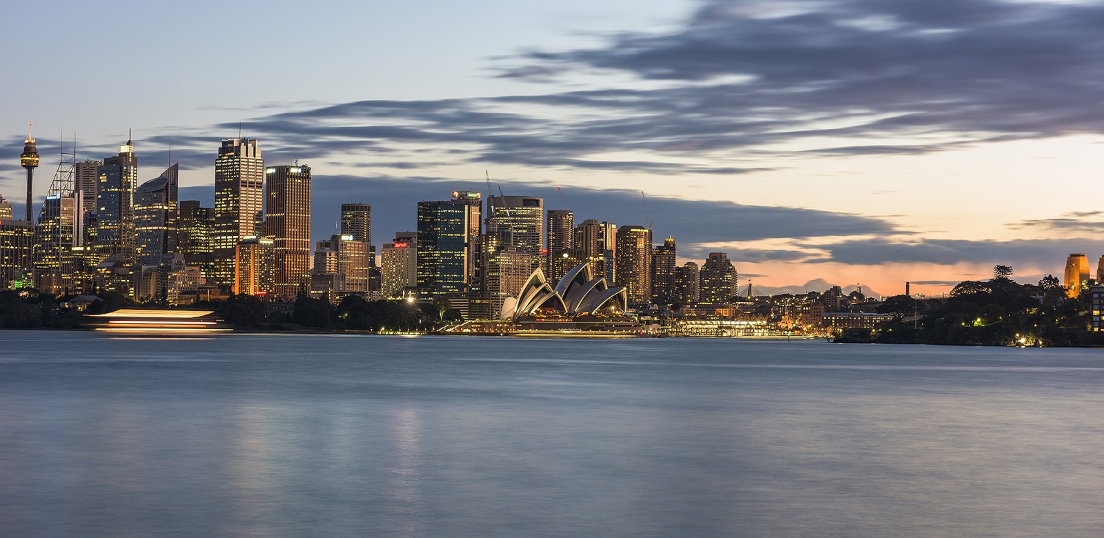 a bridge over a body of water with a city in the background