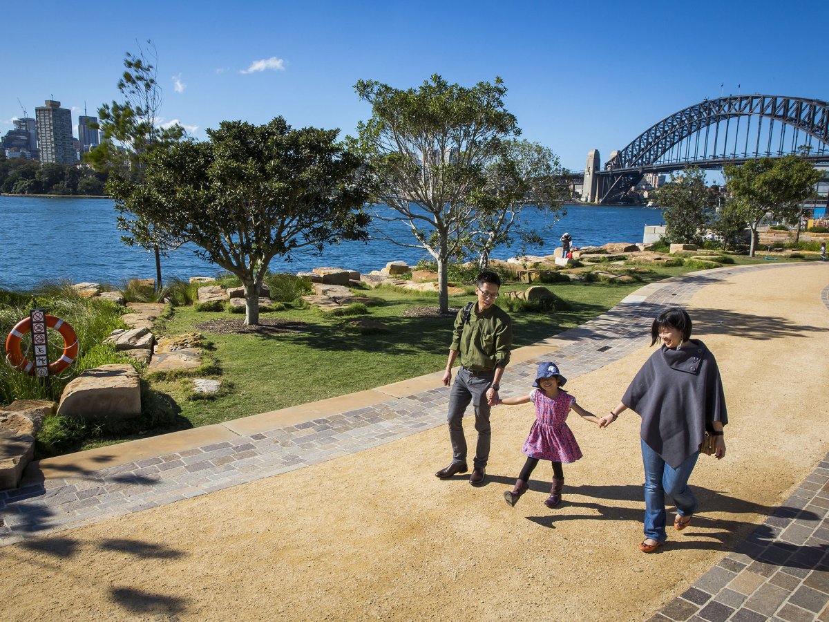 a group of people walking on a bridge over a body of water