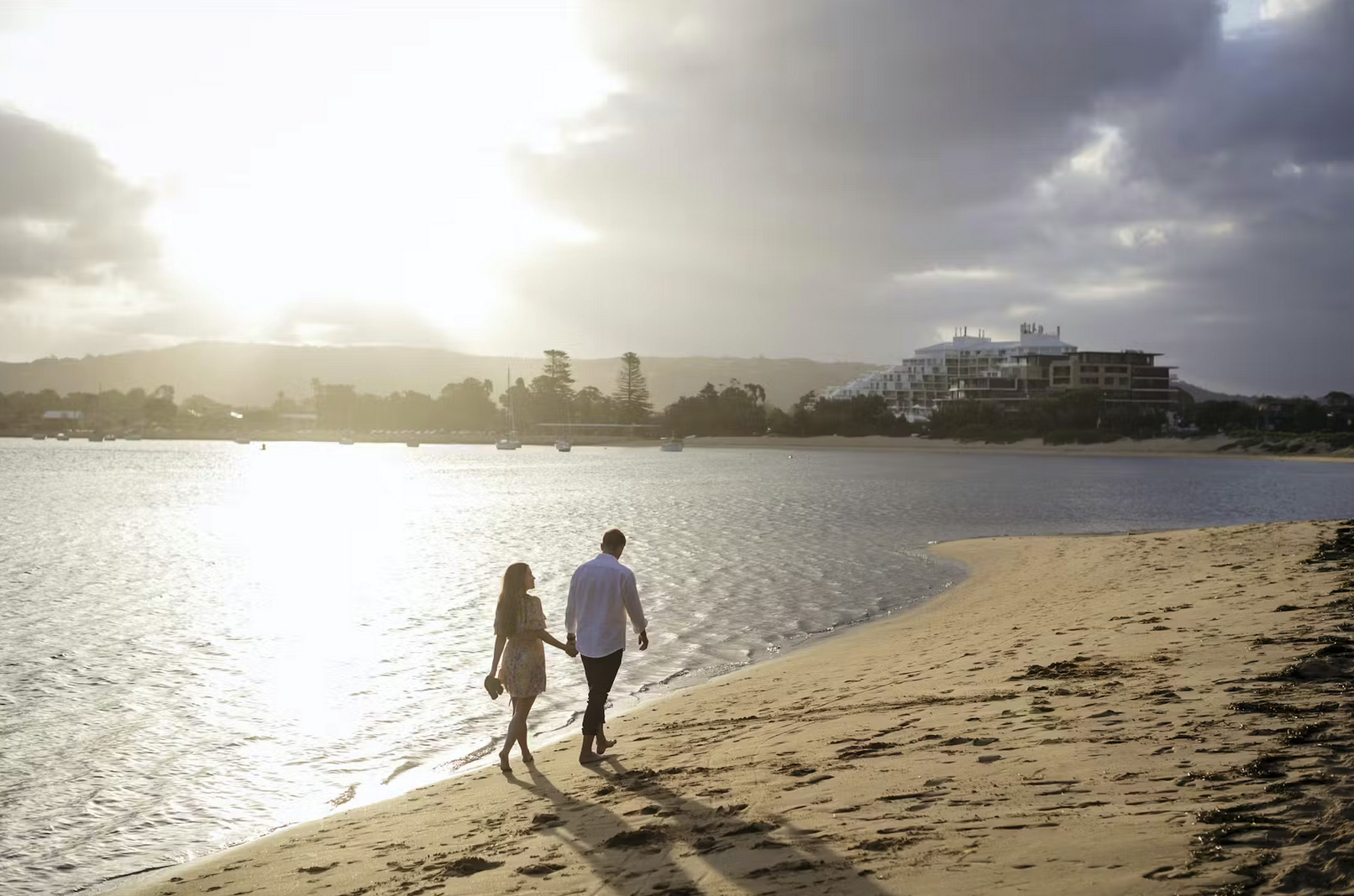 1 a man walking across a beach next to a body of water