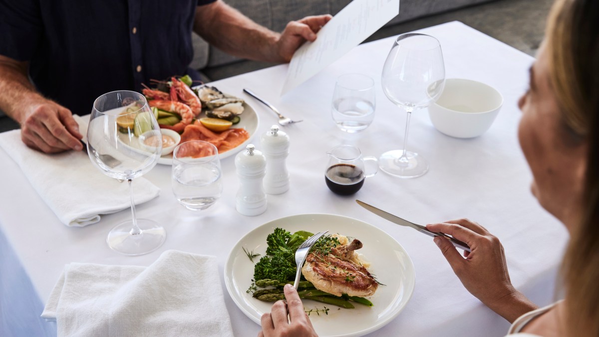JBCS-Experiences-Interior-Food-Beverage-4 a person sitting at a table with a plate of food