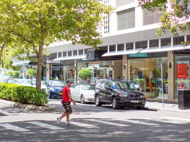a person walking down a street next to a building