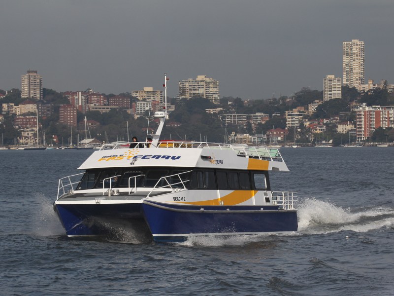 a large ship in a body of water with a city in the background