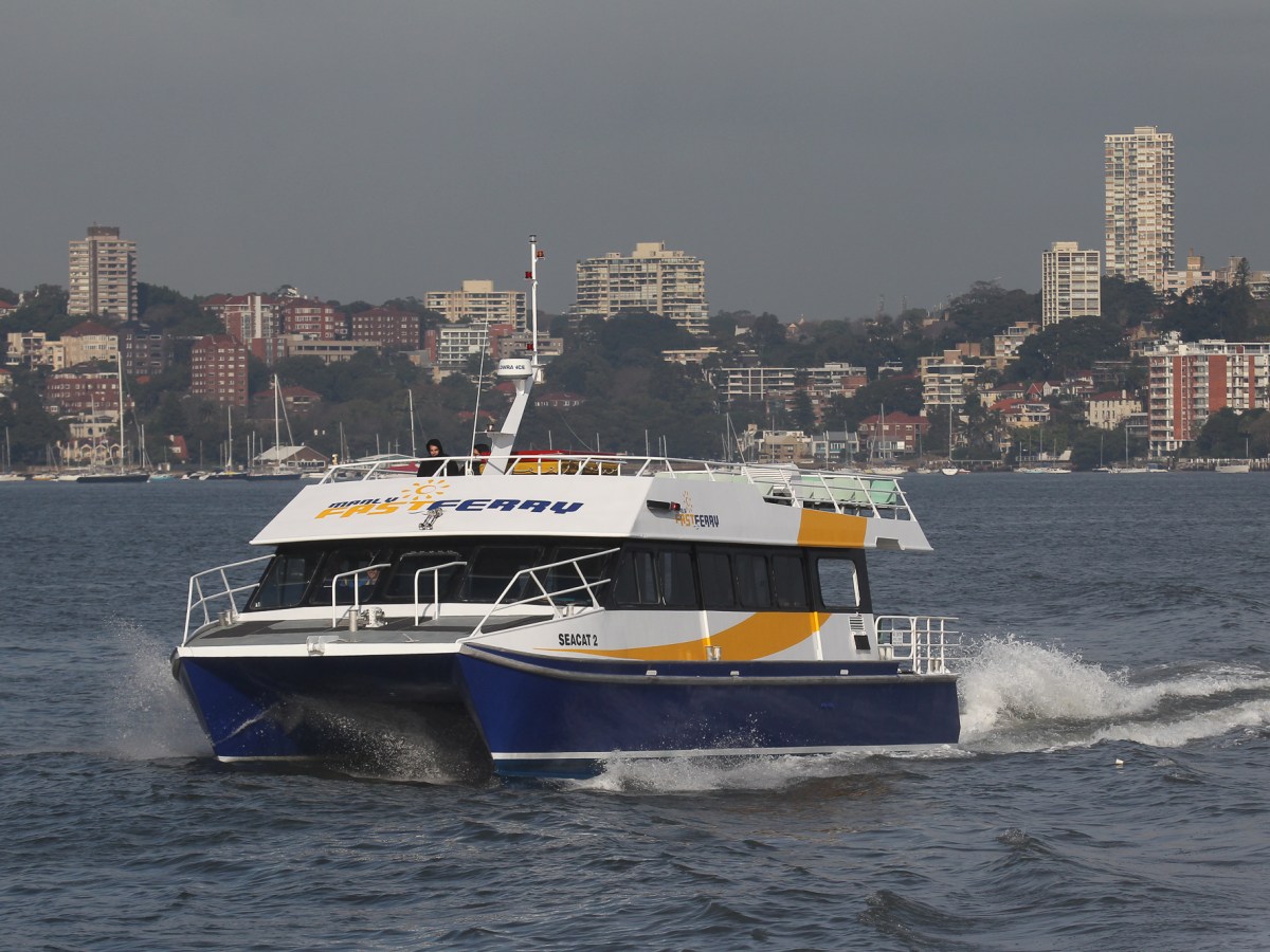 a large ship in a body of water with a city in the background